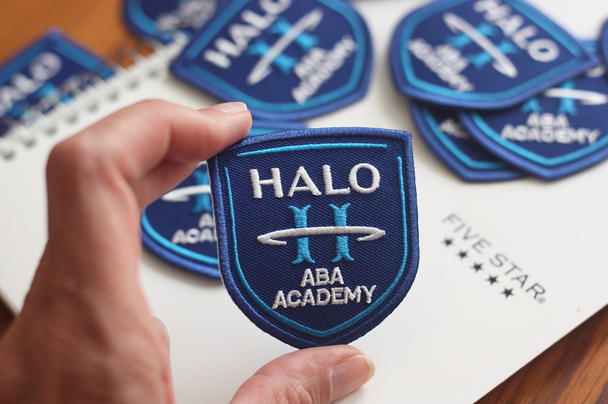 Blue and white embroidered patches with client logo from Vivipins