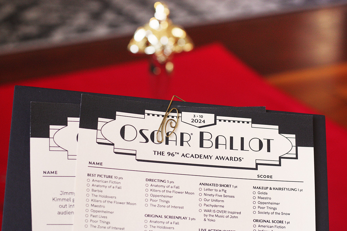 Oscar ballot and bingo pages attached to black matboard with paperclip