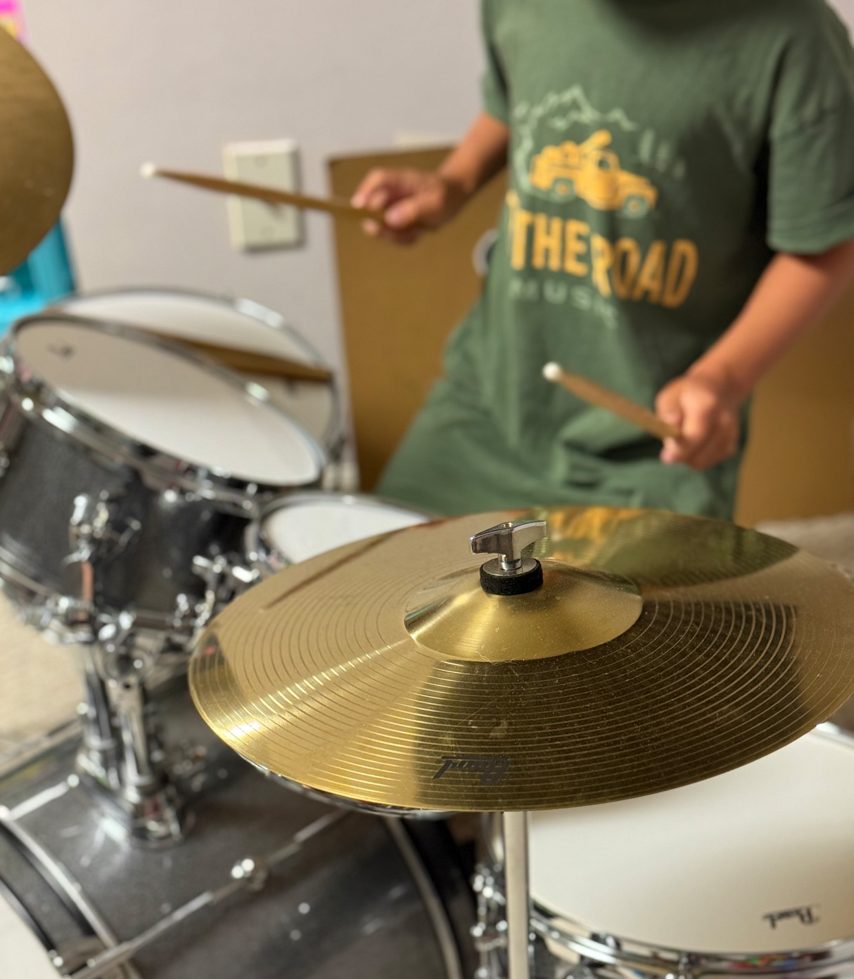 student in branded tshirt playing drums